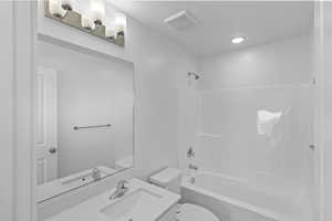 Full bath featuring visible vents, toilet,  shower combination, and vanity