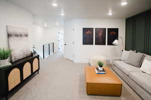 Carpeted living room with baseboards, visible vents, and recessed lighting