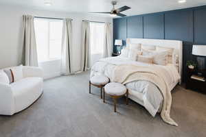 Bedroom with light carpet, a decorative wall, and a ceiling fan