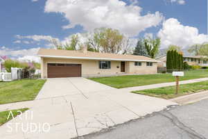Ranch-style home featuring a front yard, a garage, and fence