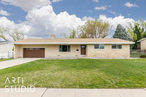 Ranch-style home featuring brick siding, fence, a garage, a front yard, and concrete driveway