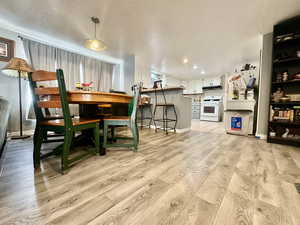 Dining area with baseboards, recessed lighting, ornamental molding, and light wood-type flooring