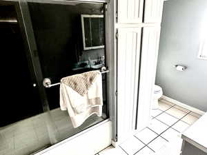 Bathroom with tile patterned floors, baseboards, vanity, and toilet