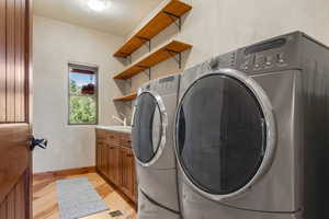 Laundry area includes washer and  dryer, and cabinets for extra storage.