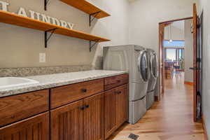 Laundry room featuring granite counter top and sink.