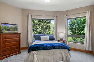 Bedroom featuring picture windows with views of  trees and wildlife in their natural habitat.