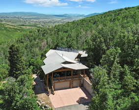 Aerial view of property and surrounding area featuring a mountainous background