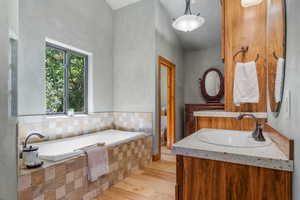 Primary ensuite with soaking tub and seperate curved shower with multi, rain shower heads.