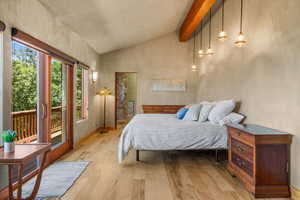 Bedroom featuring solid wood  beamed lofted ceiling with direct access to the deck and hot tub.