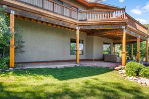 Back of house with a covered patio, a yard, and huge reinforced  deck