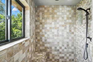 Bathroom with tiled shower and healthy amount of natural light