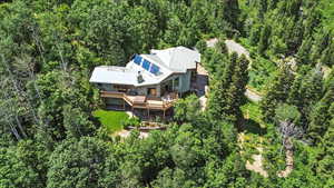 Aerial view of property and surrounding area featuring a heavily wooded area