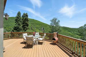 Deck featuring outdoor dining area and a view of trees