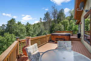 Huge Deck with a views for days, dining space, and a hot tub.