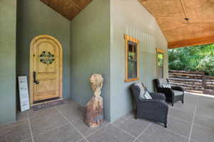 Doorway to property featuring stucco siding and a porch