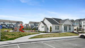 Multi unit property featuring a front lawn, a residential view, playground community, and uncovered parking