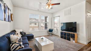 Living area with visible vents, baseboards, and a ceiling fan