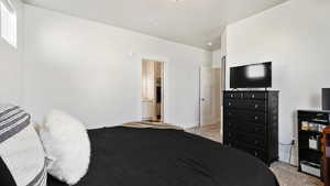 Bedroom featuring baseboards and light carpet