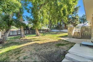 View of yard with a patio, a fenced backyard, and a deck