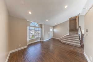 Interior space with recessed lighting, stairway, dark wood-style flooring, and baseboards