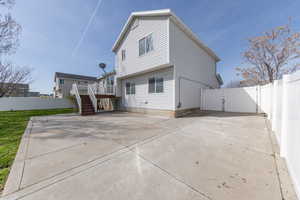 Rear view of property featuring stairway, Large patio area, a fenced backyard, a deck, and a gate
