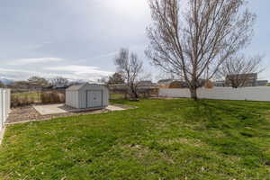 View of back yard with no neighbors, mountain views, storage shed, a fenced backyard.