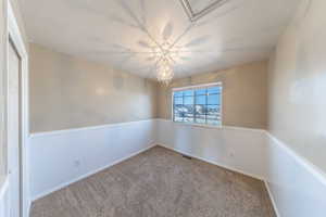 Bedroom 2 with a notable chandelier, baseboards, carpeted flooring.