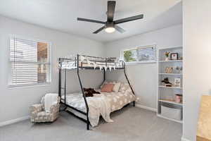 Bedroom with ceiling fan, baseboards, and carpet floors