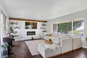 Living room off entry featuring a large fireplace, wood finished floors, big windows w/sunset views