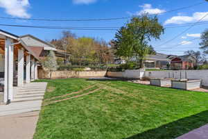 View of yard with a garden and fence
