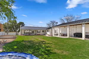 Rear  Courtyard view of property featuring a garden, a patio area, a yard, and metal roof