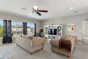 Living area featuring light carpet, baseboards, a ceiling fan, and recessed lighting