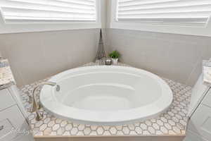 Full bathroom with a garden tub and vanity
