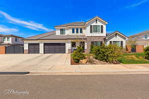 Traditional-style home featuring concrete driveway, brick siding, a garage, a tiled roof, and a gate