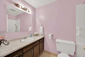 Bathroom with visible vents, baseboards, toilet, vanity, and tile patterned flooring
