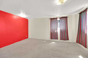 Carpeted empty room with a textured ceiling