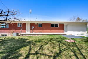 Ranch-style house with a front yard, brick siding, and cooling unit