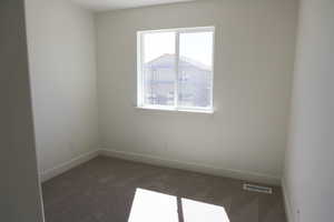 Unfurnished room with visible vents, baseboards, and carpet floors