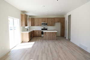 Kitchen featuring stainless steel appliances, visible vents, light countertops, and a sink
