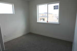Carpeted spare room with baseboards