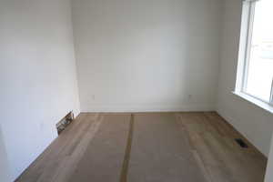 Empty room featuring visible vents, baseboards, and a healthy amount of sunlight