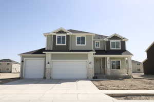 Craftsman inspired home with concrete driveway, roof with shingles, stone siding, board and batten siding, and an attached garage