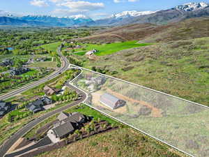 Aerial overview of property's location with a mountain backdrop and property parcel outlined