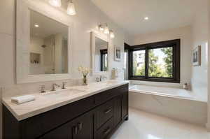 Full bath featuring a garden tub, double vanity, a shower, and tile patterned flooring