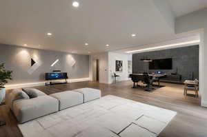 Living room with light wood-type flooring and recessed lighting