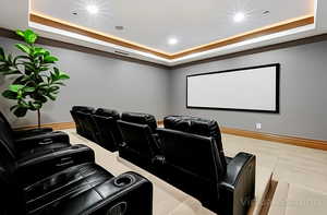 Home theater featuring a raised ceiling and recessed lighting