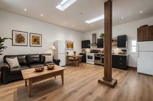 Living room featuring a skylight and light wood-style flooring