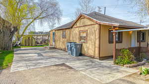 View of home's exterior with roof with shingles and a patio area
