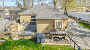 Back of house with fence and a shingled roof