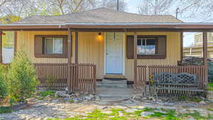 Entrance to property with roof with shingles
